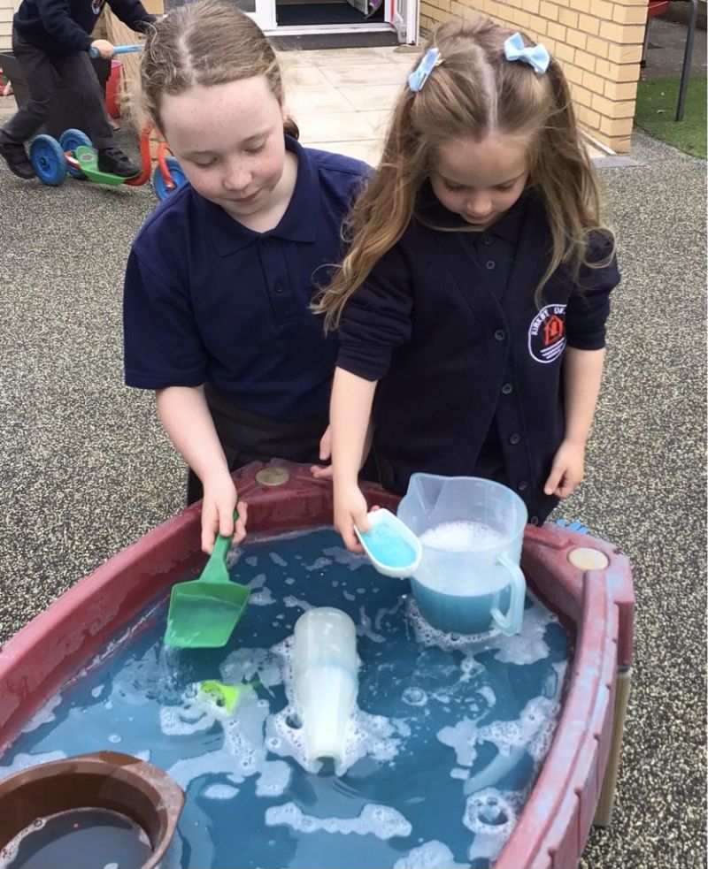 two children playing with a water tray